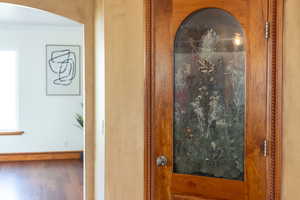 Room details featuring arched walkways, wood finished floors, and baseboards