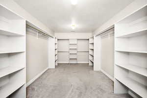 Spacious closet with light colored carpet