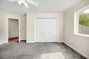 Unfurnished bedroom with crown molding, a closet, carpet, and baseboards