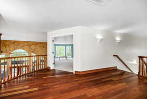 Interior space featuring baseboards, visible vents, wood finished floors, and a notable chandelier
