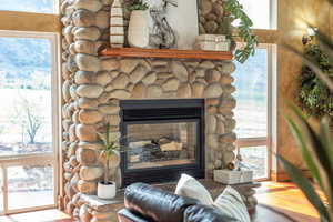 Interior details featuring a stone fireplace and wood finished floors