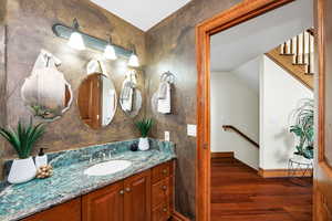 Bathroom with baseboards, wood finished floors, and vanity