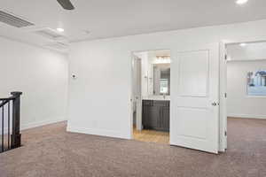 Interior space with baseboards, visible vents, light colored carpet, and recessed lighting