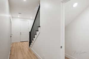 Staircase featuring recessed lighting, visible vents, wood finished floors, and baseboards