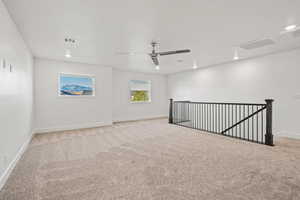 Unfurnished room featuring visible vents, a ceiling fan, and light carpet