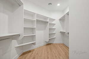 Walk in closet featuring visible vents and light wood-type flooring