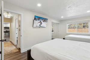 Bedroom featuring a closet, recessed lighting, dark wood finished floors, and baseboards