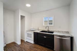 Kitchen featuring stainless steel dishwasher, white range with electric cooktop, dark cabinetry, dark wood-style floors, and a sink