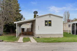 Manufactured / mobile home featuring a carport and a front lawn