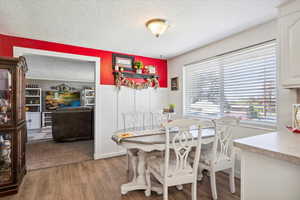 Dining area featuring a textured ceiling and light wood-style flooring