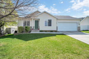Ranch-style home featuring stucco siding, fence, a front yard, concrete driveway, and an attached garage