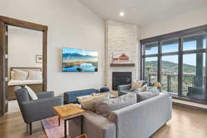 Living area featuring a fireplace, wood finished floors, recessed lighting, and high vaulted ceiling