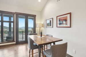 Dining space featuring a mountain view, visible vents, high vaulted ceiling, and wood finished floors