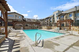Community pool with fence, a pergola, and a patio area
