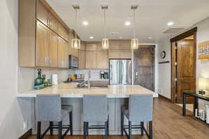 Kitchen featuring tasteful backsplash, stainless steel appliances, a sink, baseboards, and a peninsula
