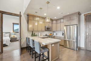 Kitchen featuring visible vents, a peninsula, stainless steel appliances, and light wood-type flooring