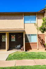 Property entrance with stucco siding and covered porch