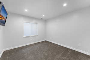 Spare room with visible vents, dark colored carpet, baseboards, and recessed lighting