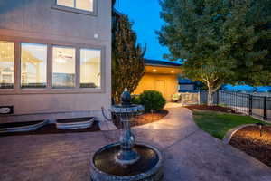 View of front of home featuring fence, stucco siding, and a patio area