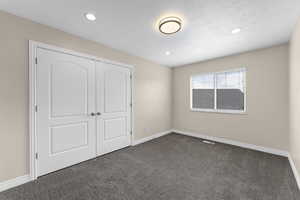 Unfurnished bedroom featuring recessed lighting, a closet, baseboards, visible vents, and dark carpet