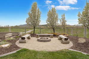 View of patio featuring a fire pit, fence private yard, a mountain view, and a garden