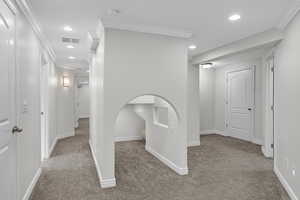 Hallway featuring ornamental molding, recessed lighting, visible vents, and carpet