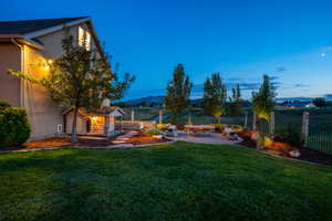 View of yard featuring a patio, a fire pit, fence, and a mountain view