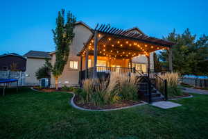 View of front facade featuring a pergola, central air condition unit, a trampoline, and a front lawn