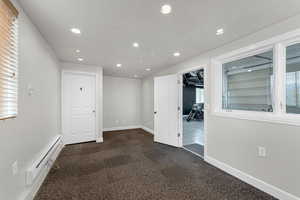 Finished office in Detached Garage with recessed lighting, a baseboard heating unit, and baseboards