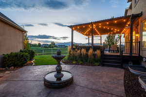 View of patio featuring fence and a deck with mountain view
