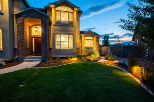 View of front of property featuring stucco siding, fence, and a front yard