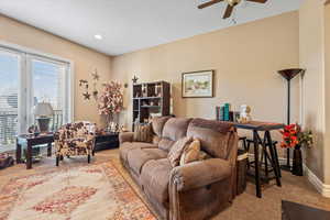 Carpeted family room featuring baseboards, recessed lighting, and ceiling fan