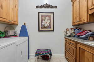 Laundry room featuring baseboards, washer and clothes dryer, cabinet space & extra deep sink