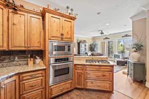 Kitchen with stainless steel appliances, ornamental molding, a peninsula, tasteful backsplash, and open floor plan