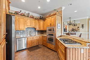 Kitchen with crown molding, stainless steel appliances, a sink