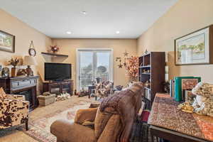 Family room  with a glass covered fireplace, carpet flooring, and recessed lighting