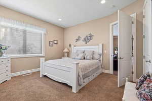 Large carpeted bedroom featuring baseboards, recessed lighting & breeze through windows from Rock Canyon.