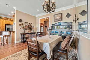 Dining area featuring a chandelier, baseboards, ornamental molding, and recessed lighting