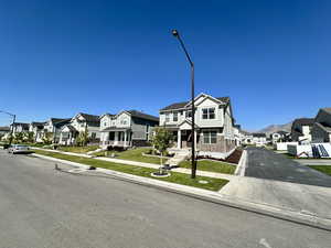 View of front of home featuring a residential view, a front yard, and aphalt driveway