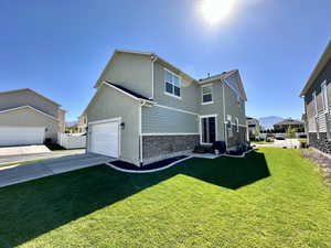 Back of property with a garage, a residential view, a yard, stucco siding, and entry steps