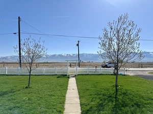 View of yard with fence, a rural view, and a mountain view