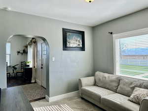 Living area with baseboards and arched walkways and ample light to fill the room with cheer
