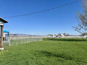 View of yard featuring a mountain view, fence, and a rural view