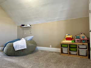 Family room with baseboards, carpet floors, and vaulted ceiling