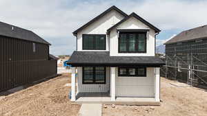 View of front facade featuring a shingled roof and board and batten siding
