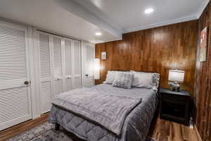 Bedroom featuring recessed lighting, wood finished floors, and wooden walls