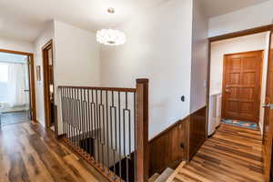 Corridor featuring washer and dryer, wood finished floors, and an upstairs landing