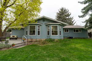 Back of property featuring a patio, a lawn, central AC unit, and fence