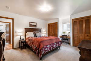 Bedroom featuring two closets and light colored carpet