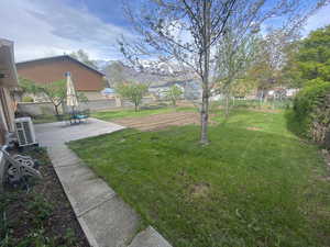 View of yard featuring a fenced backyard, ac unit, and a patio area